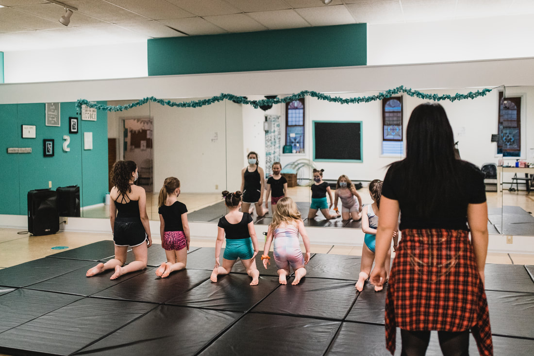 An acro class stretching on the studio mats