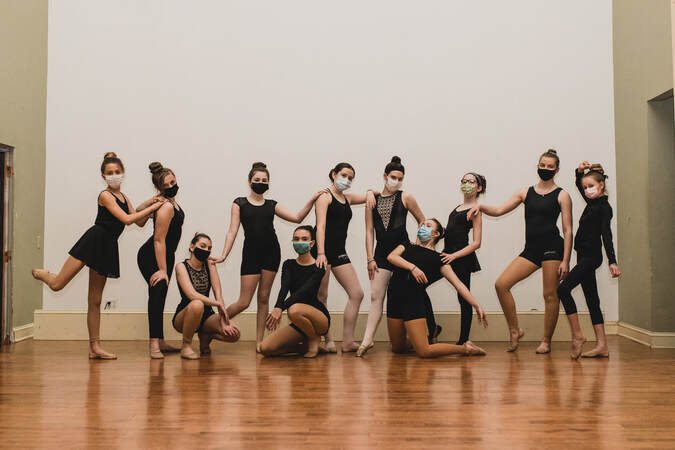 A group of Signature Dance students posed together on the studio floor